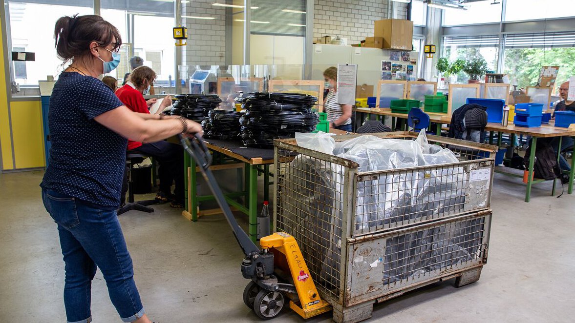 zu sehen ist eine Dame mit Hubwaagen in Werkstatt